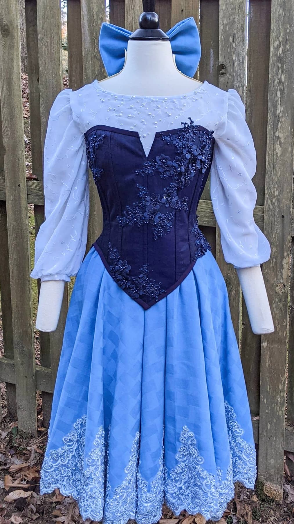 Blue Cinderella-inspired gown with a navy beaded corset bodice on a dress form