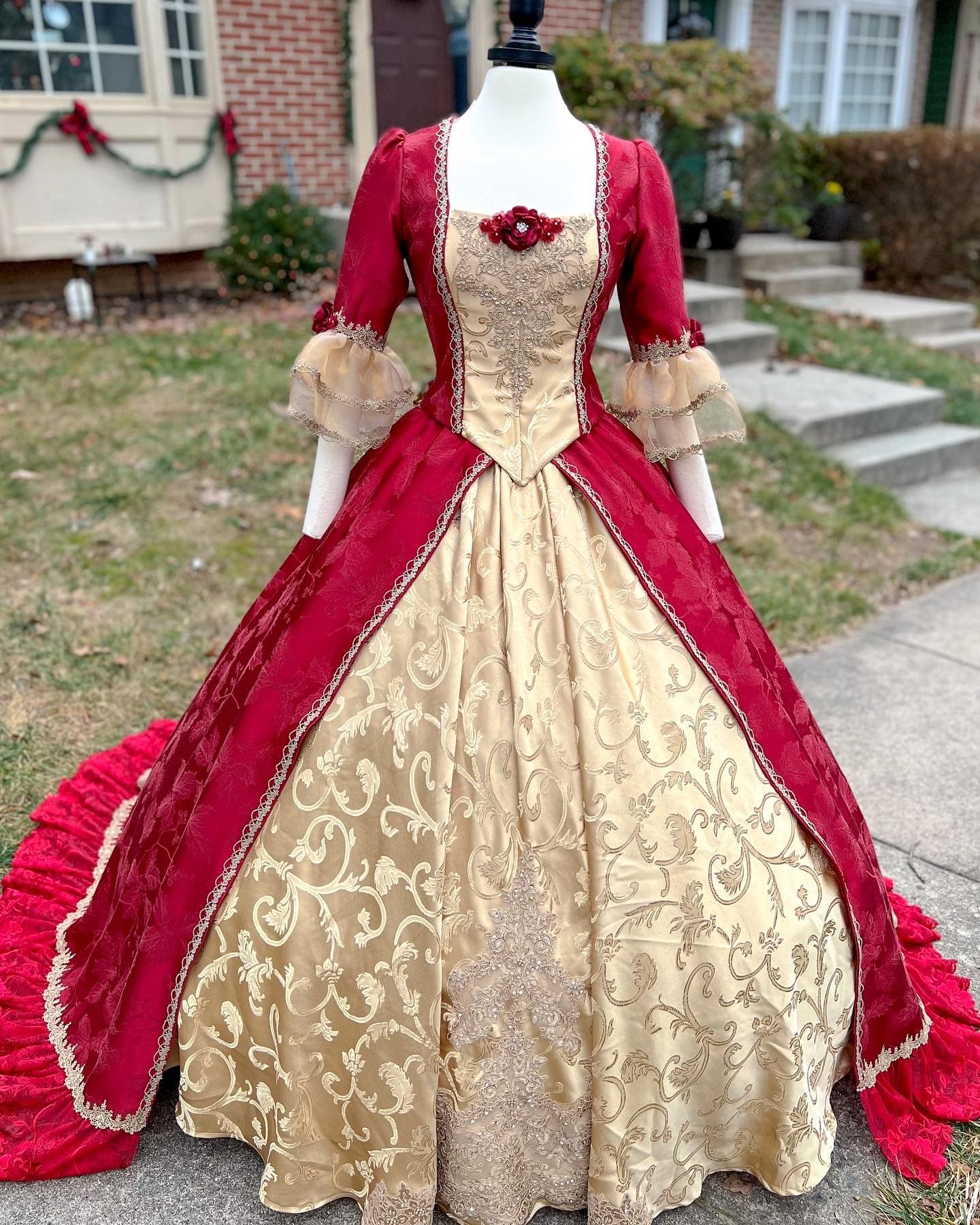 Red and gold Rococo ball gown with a brocade skirt on a dress form